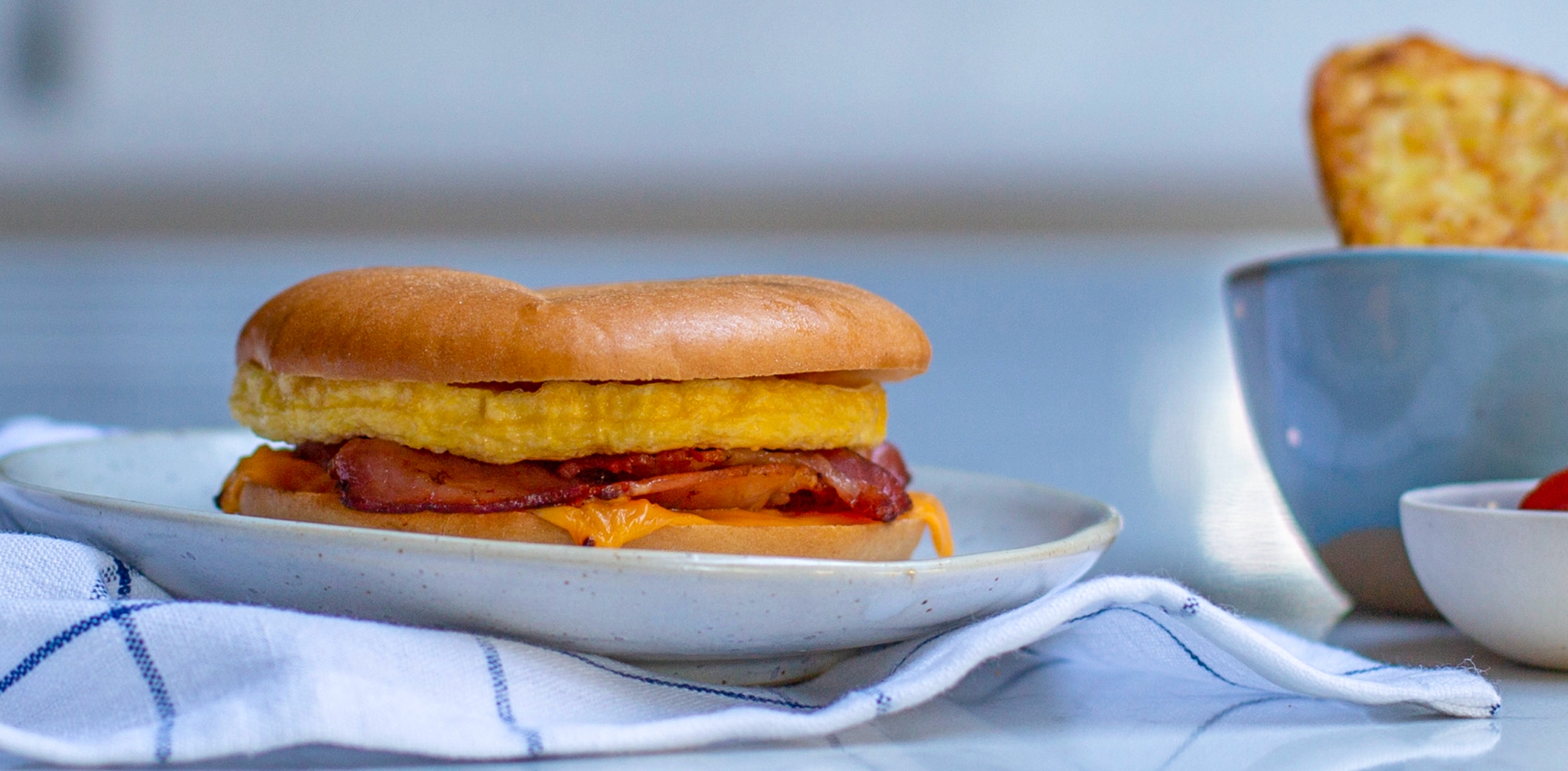 https://drewandcole.com/wp-content/uploads/2021/10/Breakfast-Maker-Hub-Images-Classic-Bacon-Egg-and-Cheese-Bagel.jpg